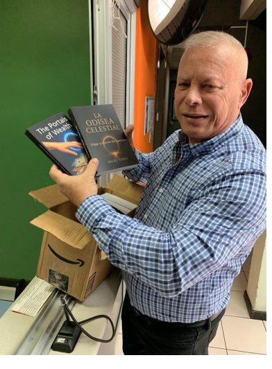 Angel Viera sosteniendo ejemplares de sus libros